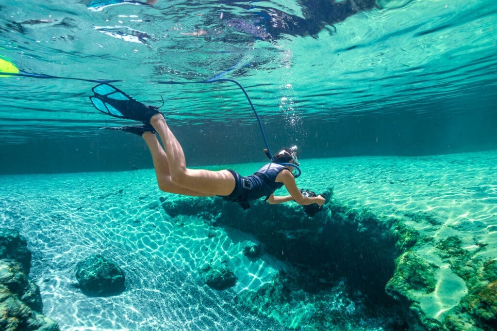kimber-water-bear-photography-documenting-springs-using-blu3-system Kimber of Water Bear Photography submerged in clear spring waters using the BLU3 dive system, with camera ready
