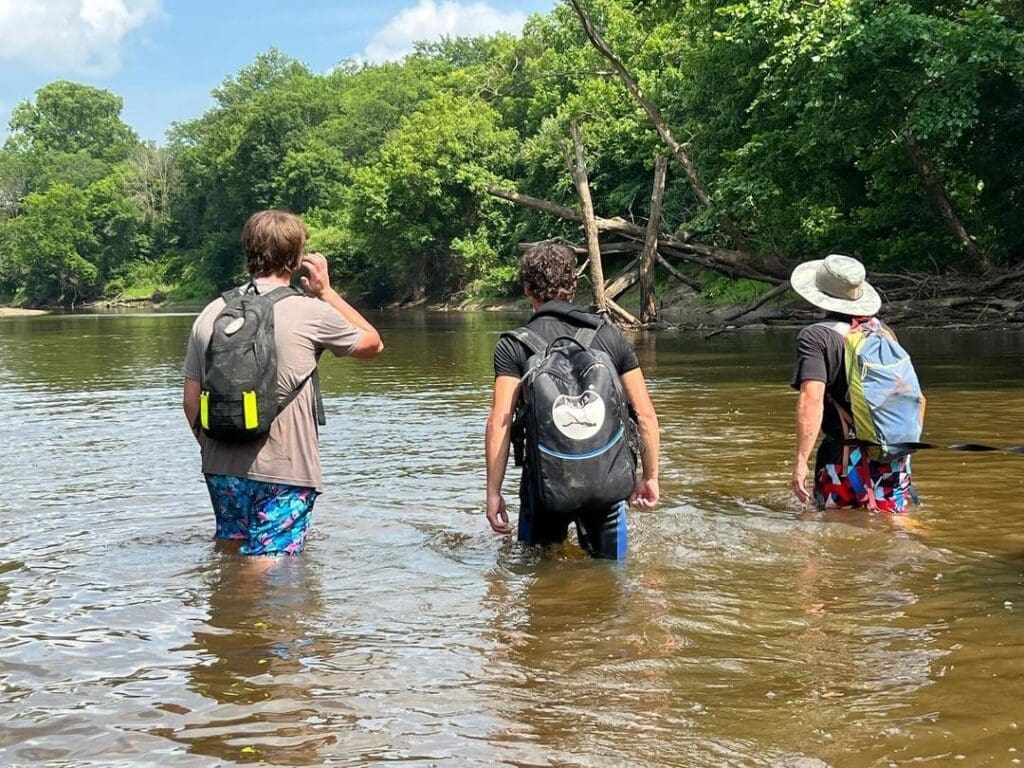 russian-archaeologist-exploring-river-blu3-dive-system The Russian Archaeologist and team walking through a river with BLU3 Nomad dive system backpacks