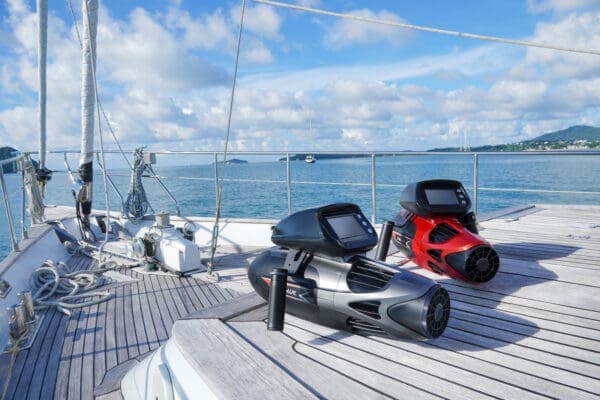 Sublue Vapor underwater scooters in red and gray on yacht deck with ocean view