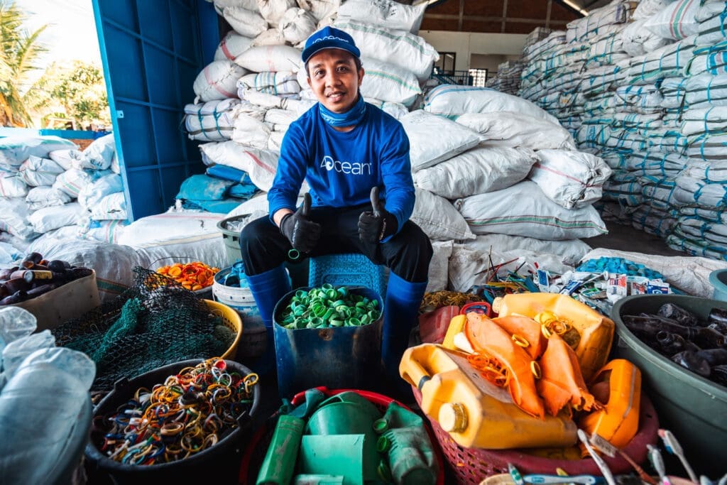 4ocean cleanup crew member sorting recovered ocean plastic and fishing gear at a recycling facility.
